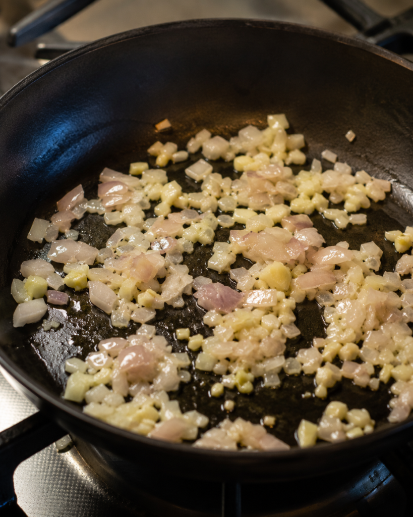 Shallot and garlic cooking in a skillet for vegan mac and cheese