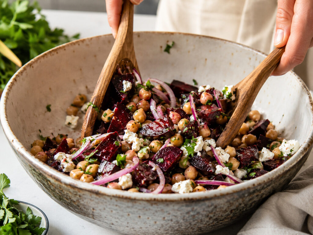 chickpea beet feta salad being mixed in a large bowl