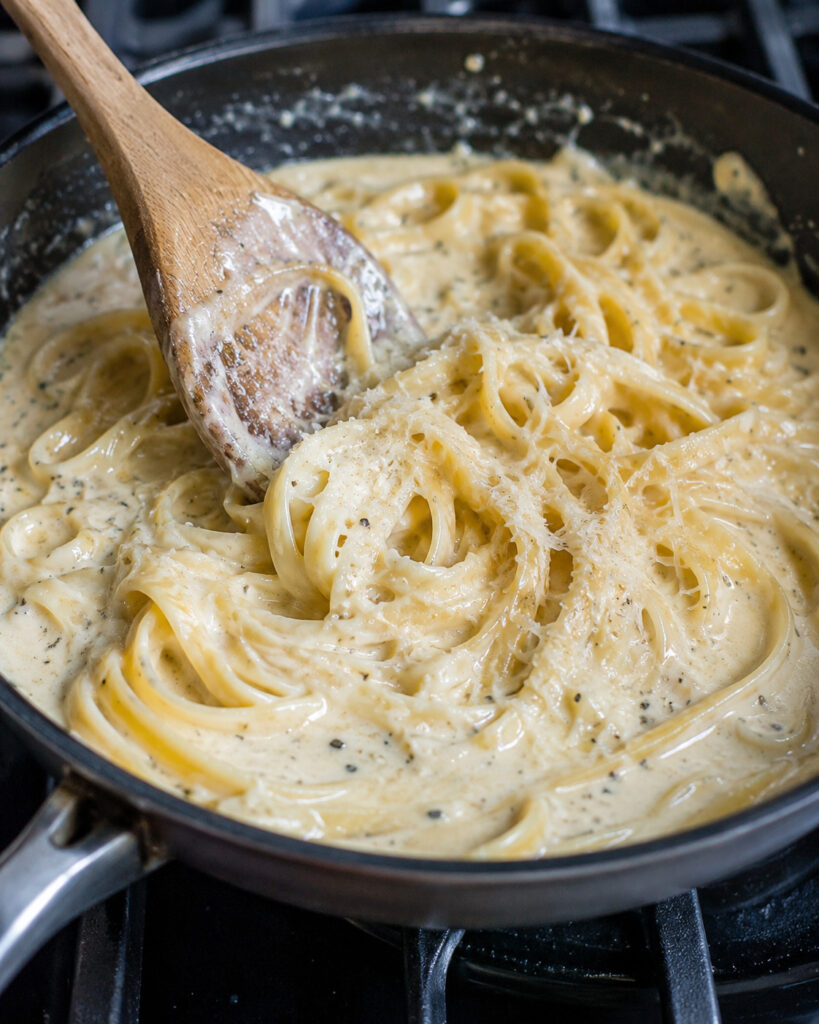 creamy parmesan sauce coating pasta in a skillet
