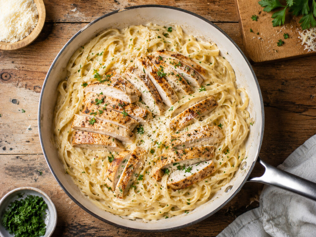 Garlic parmesan chicken pasta cooked in skillet.