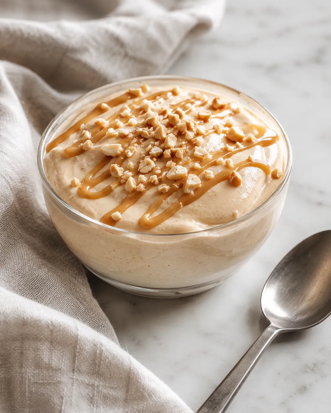 Cottage cheese peanut butter mousse in a bowl with peanut butter drizzle