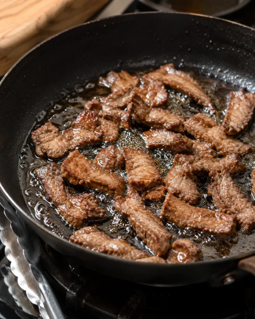 Beef strips frying in hot oil until crisp for crispy chilli beef rice